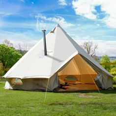 a large white tent sitting on top of a lush green field