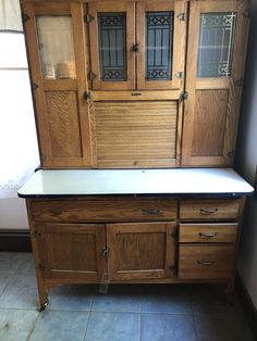 an old wooden cabinet with glass doors on it's sides and drawers below the door