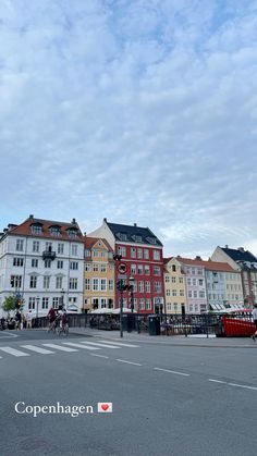 several buildings line the street in front of a cloudy sky