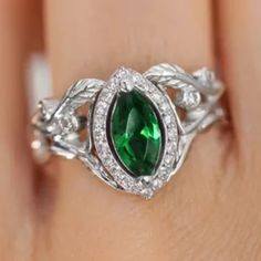 a woman's hand with a green ring on it