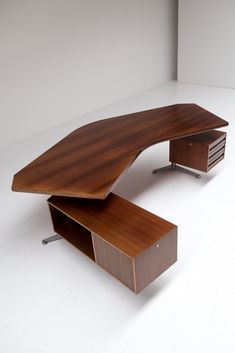 a wooden desk sitting on top of a white floor