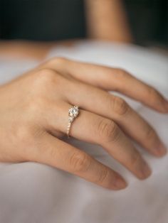 a woman's hand with a diamond ring on it