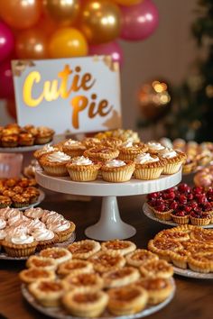 a table topped with lots of pies and cupcakes