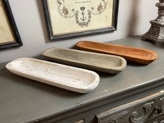 two wooden trays sitting on top of a dresser