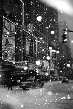 a black and white photo of traffic on a snowy day