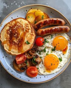 a breakfast plate with eggs, sausages, tomatoes and mushrooms on it is shown