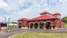 a fire station with red roof and white trim