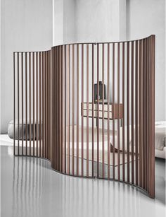 a room divider with wooden slats in the middle and two chairs behind it