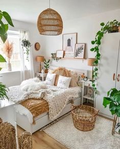 a bedroom with white walls and lots of greenery in the room, including plants