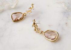 Our Juniper Branch Earrings are perfectly boho chic. They're simple, dainty and won't overpower your entire look on your special day! These also make a perfect gift for bridesmaids for a classic bohemian look.FEATURES Champagne hued glass drops set in 16k gold plating White cubic zirconia encrusted leaf post (925 sterling post) 100% nickel free, can be worn by people with sensitive ears Branch Earrings, Chain Extenders, Oils For Skin, Polish Jewelry, Gold Filled Jewelry, Real Gold, Cleaning Jewelry, Custom Jewelry, Bridesmaid Gifts