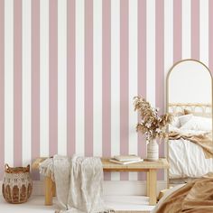 a bedroom with pink striped wallpaper and a mirror on the side table next to a bed