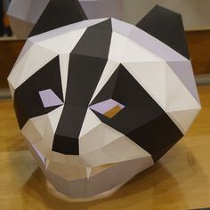 an origami panda bear head sitting on top of a wooden table