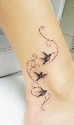 a woman's foot with two birds on it and swirls around the ankles