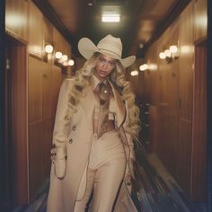 a woman with long blonde hair wearing a cowboy hat and trench coat in an elevator