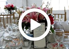 the table is set for an event with place settings and flowers in vases on it