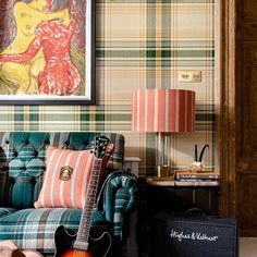 a living room filled with furniture and a guitar in front of a painting on the wall