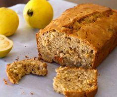 sliced loaf of banana bread next to two lemons and an apple on the table