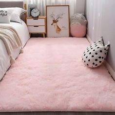 a bedroom with a pink rug on the floor and a bed in the corner next to it