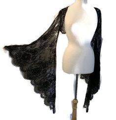 This shrug is made of black eyelet lace fabric. It has huge flared bell sleeves. Small fits a bust of 30" to 33".  Medium fits a bust of 33" to 36".  Small and Medium sleeves measure 17" around bicep area. Large fits a bust of 36" to 39". XLarge fits a bust of 39" to 42" .  Large and Xlarge sleeves measure 18" around bicep area. 2X fits a bust of 39" to 42". 3X fits a bust of 42" to 45".  2X and 3X sleeves measure 19" around bicep area. Sleeve length from shoulder to hem is 25". Down center back it measures 12". Sleeve hem circumference is 75". Elegant Black Long Sleeve Shrug, Goth Bolero, Black Gothic Top With Sheer Sleeves, Gothic Bell Sleeve Top, Gothic Long Sleeve Sheer Top, Eyelet Lace Fabric, Gothic Witch, Dress Sleeves, Goth Clothing