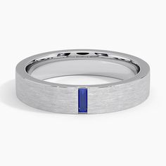 a men's wedding band with a blue stone in the center and a thin, flat