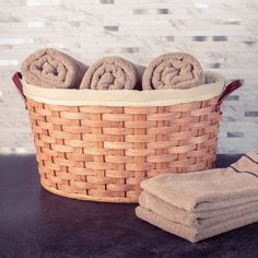 three towels in a basket next to some folded ones