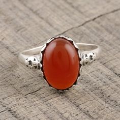 Glamorously beautiful, this cocktail ring from India is presented by Alok Jain. Local artisans craft the ring of sterling silver, caressing a large oval of red-orange carnelian with swirling vine motifs. Carnelian Ruby Ring With Oval Cabochon For Gift, Orange Oval Carnelian Rings, Oval Orange Carnelian Rings, Oval Carnelian Orange Ring, Carnelian Oval Cabochon Ring As Gift, Oval Carnelian Ring For Gift, Carnelian Oval Cabochon Ring For Gift, Oval Carnelian Wedding Rings, Handmade Oval Carnelian Ring