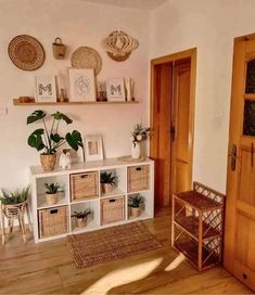 a living room filled with lots of furniture and plants on top of wooden shelves next to a door