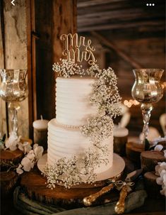 a white wedding cake sitting on top of a wooden table