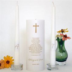 three candles with flowers and a cross on them