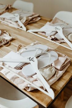 several pairs of white shoes sitting on top of a wooden table