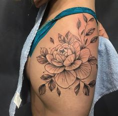 a woman's thigh with a flower tattoo on it