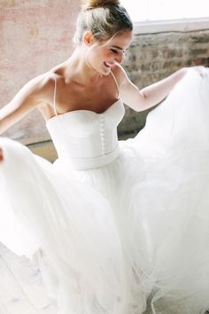 a woman in a white dress is posing for the camera