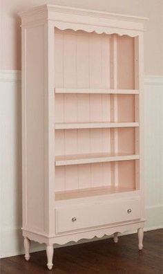 an empty white bookcase in the corner of a room