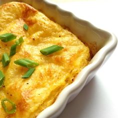 a casserole dish with cheese and green onions