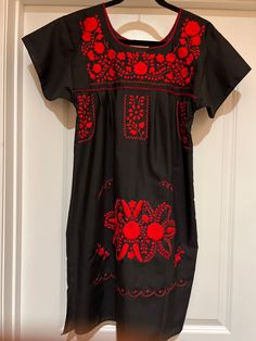 This fabulous Puebla black dress is hand made and hand embroidered  red floral design! Great spring and summer dress as well as topping it off with a jean jacket for the fall! 80% Cotton 20% Polyester Measurements! Pic 1  Small Chest:  34" Length:  35" Hip:  44" Pic 2 Medium Chest:      40" Length:    36" Hip:          48" Pic 3   Large  Chest:      40" Length:    34" Hip:          48" Pic 4      XLarge Chest:      44" Length:    36" Hip:          50" Pic 5      XLarge  Chest:      44" Length: Red Embroidered Casual Fitted Dress, Red Fitted Embroidered Casual Dress, Red Embroidered Fitted Casual Dress, Casual Red Fitted Embroidered Dress, Black Cotton Folk Embroidered Dress, Traditional Black Dress With Embroidered Neckline, Casual Red Embroidered Dress, Black Cotton Embroidered Dress With Floral Embroidery, Black Cotton Dress With Floral Embroidery