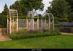 an outdoor garden with wooden trelliss and flowers