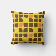 a yellow pillow with brown and orange squares on it