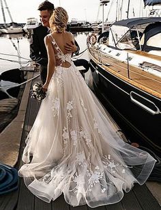 a woman in a wedding dress standing next to a boat