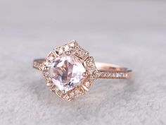 an engagement ring with a pink diamond surrounded by diamonds