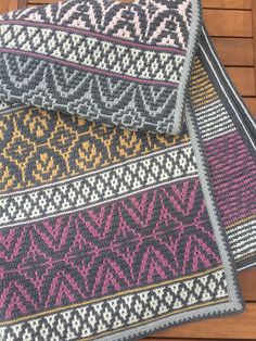 three pieces of knitted fabric sitting on top of a wooden floor next to each other