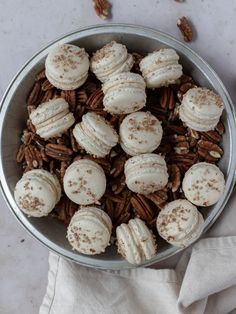 a bowl filled with ice cream and pecans on top of a white table cloth