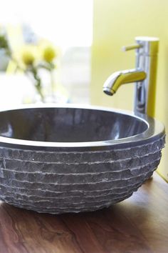 a black bowl sink sitting on top of a wooden counter