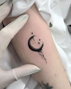 a woman's arm with a crescent and stars tattoo on it