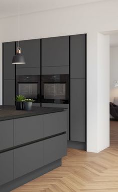 a kitchen with grey cabinets and wooden floors