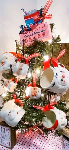 a christmas tree decorated with coffee cups and mugs in the shape of cats is on display