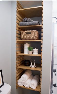 the shelves in this bathroom are filled with towels and other items, including toilet paper