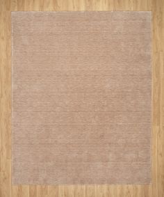 a beige rug on top of a wooden floor with a wood flooring area in the middle