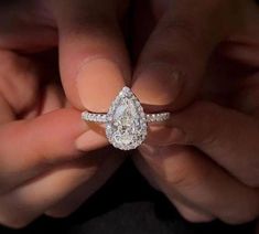 a person holding a diamond ring in their hands