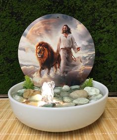 a bowl filled with rocks and a painting of jesus on it