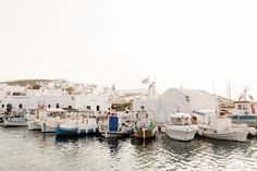 there are many boats that are docked in the water near each other and some buildings